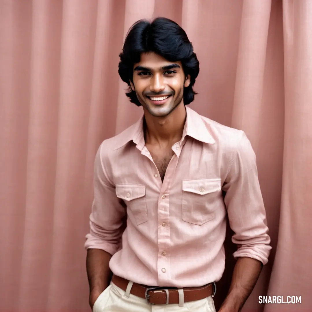 Man standing in front of a pink curtain with a smile on his face and a brown belt around his waist