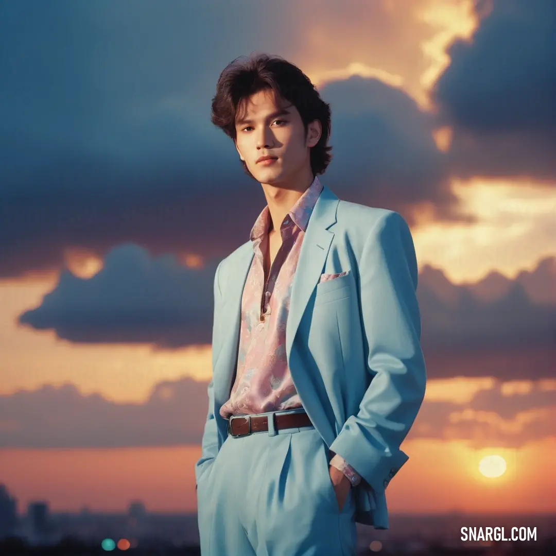 Man in a blue suit standing in front of a sunset with clouds in the background