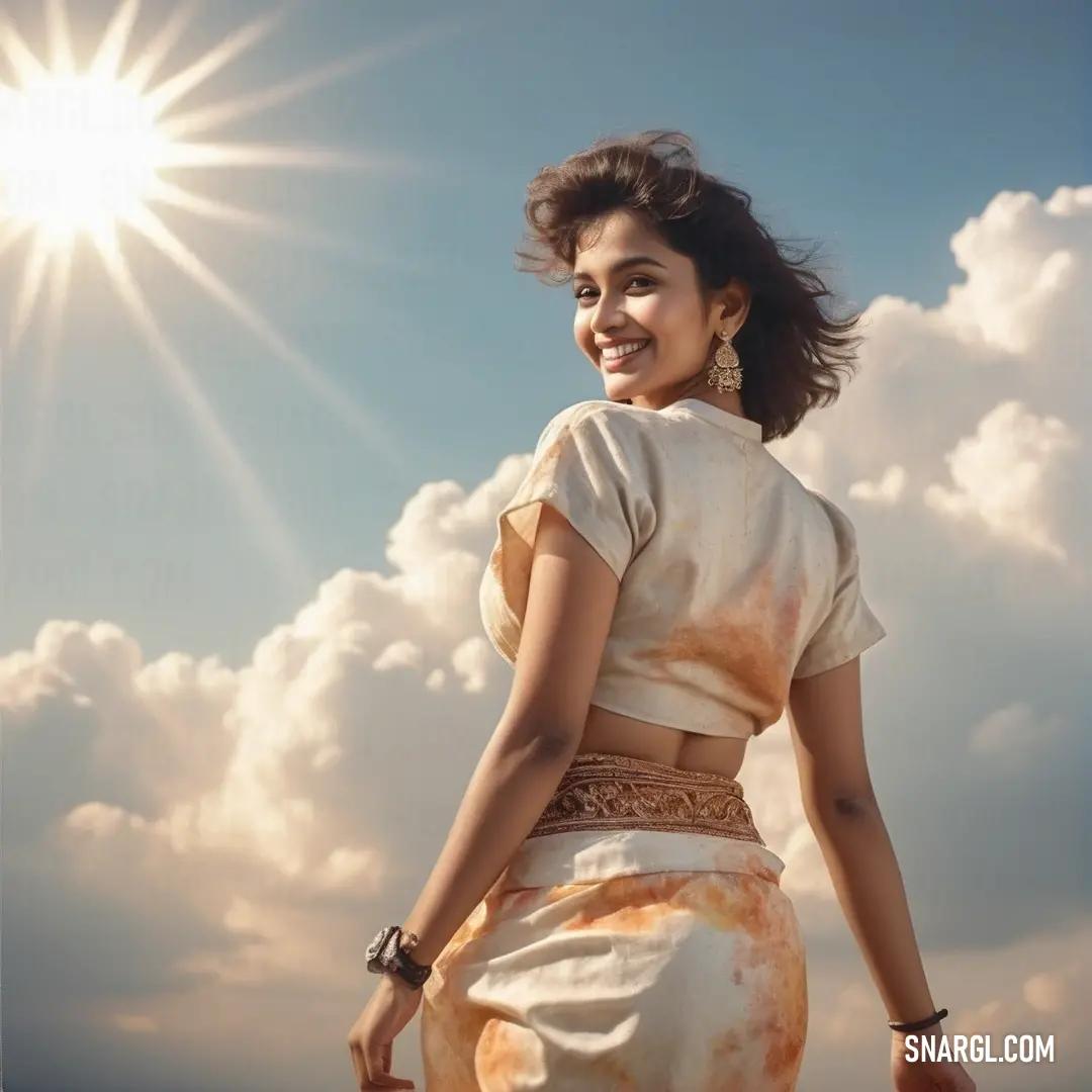 Woman in a dress standing in the sun with her hair in a bunt and smiling at the camera