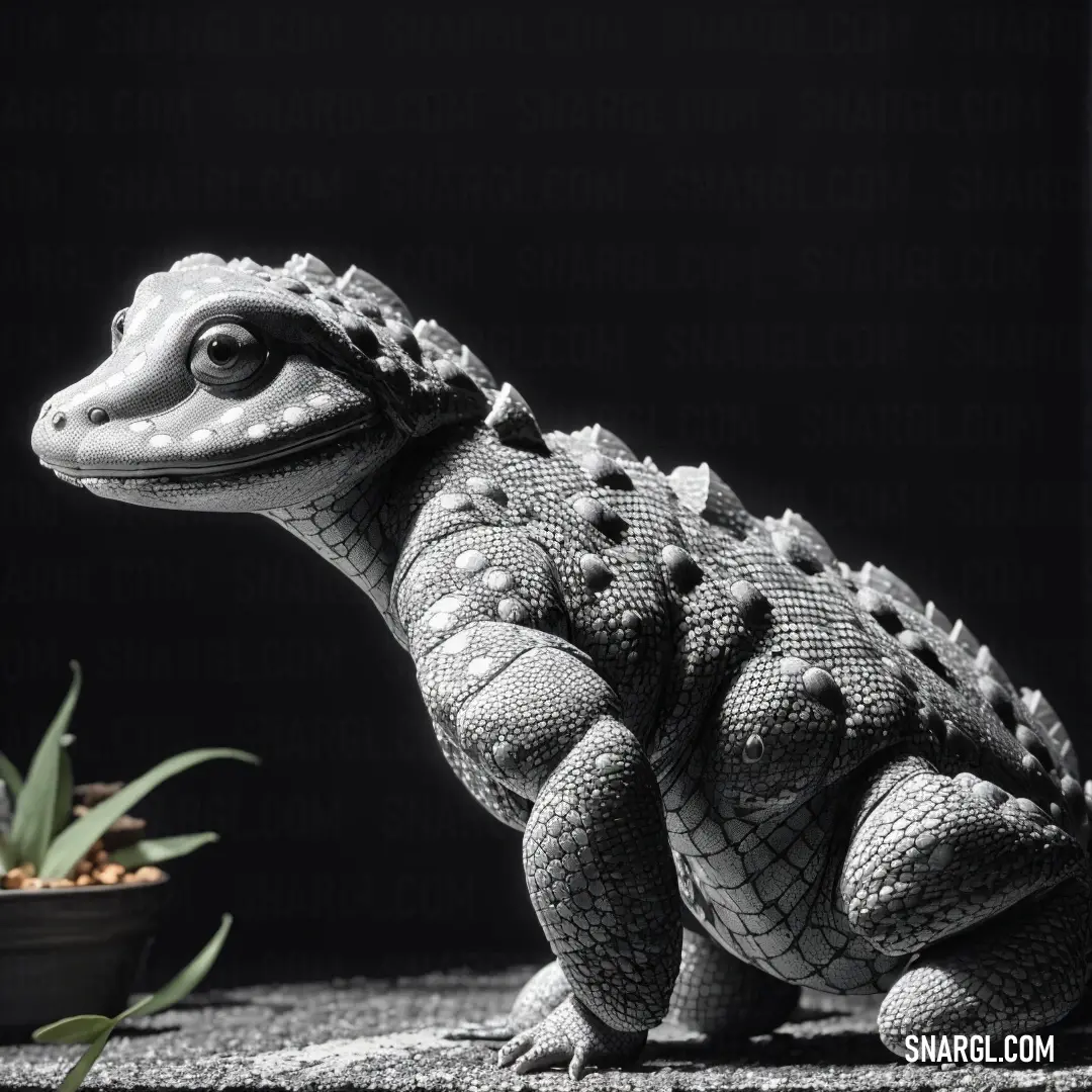 Toy alligator next to a potted plant on a table with a black background