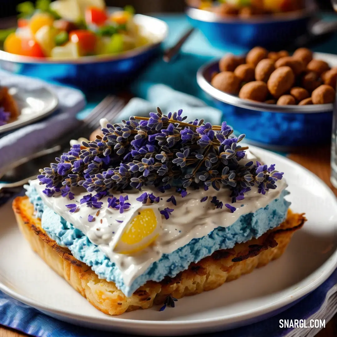 Piece of cake with blue frosting and sprinkles on it on a plate with other plates of food. Example of RGB 93,138,168 color.