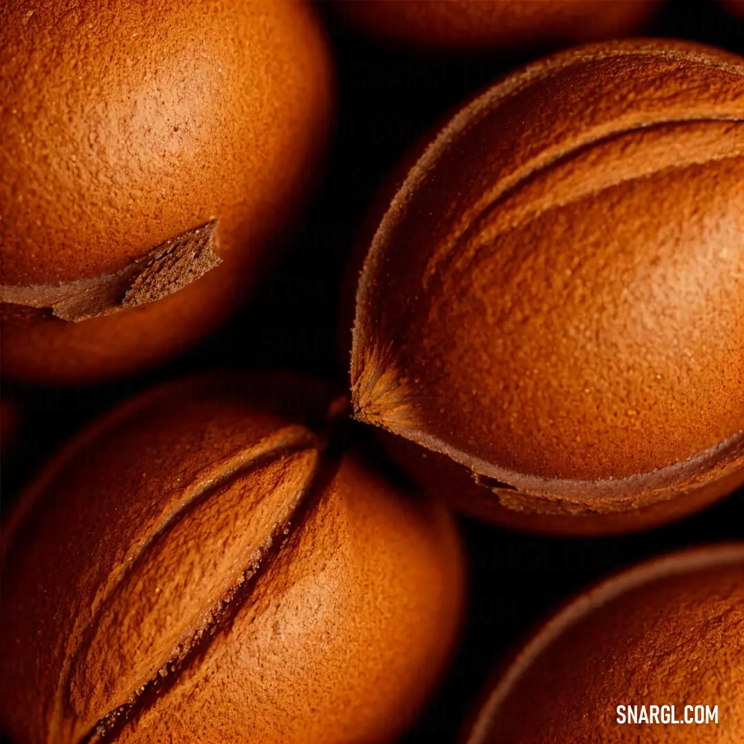 Close up of a bunch of oranges with a brown background and a brown stripe on the top