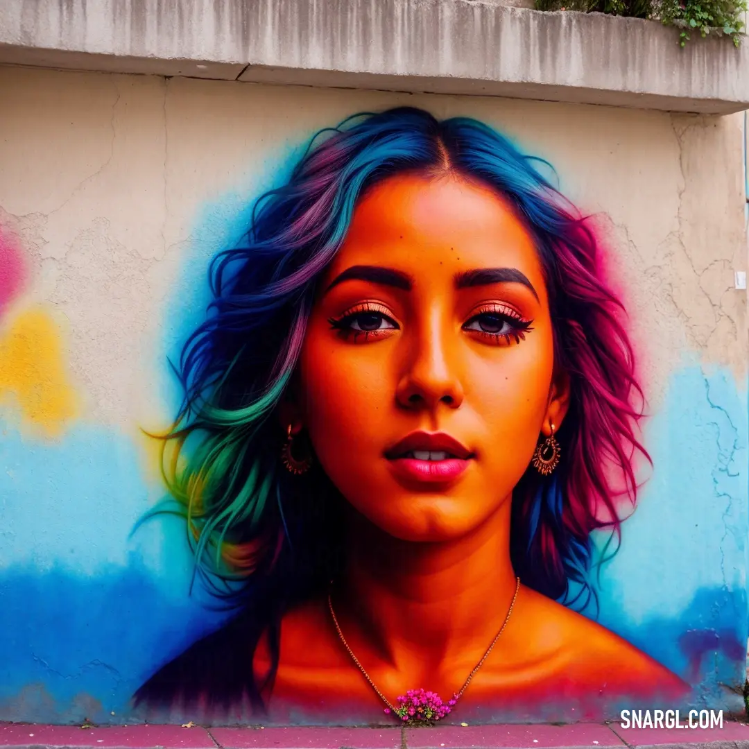 Woman's face painted on a wall with a colorful background and a pink flower in her hair