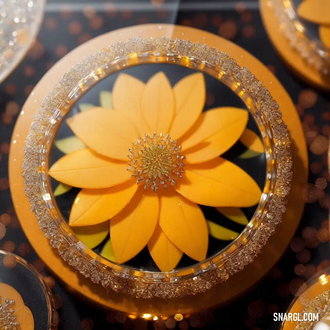 Amber color. Yellow flower is in a glass bowl on a table with gold glitters and a black background