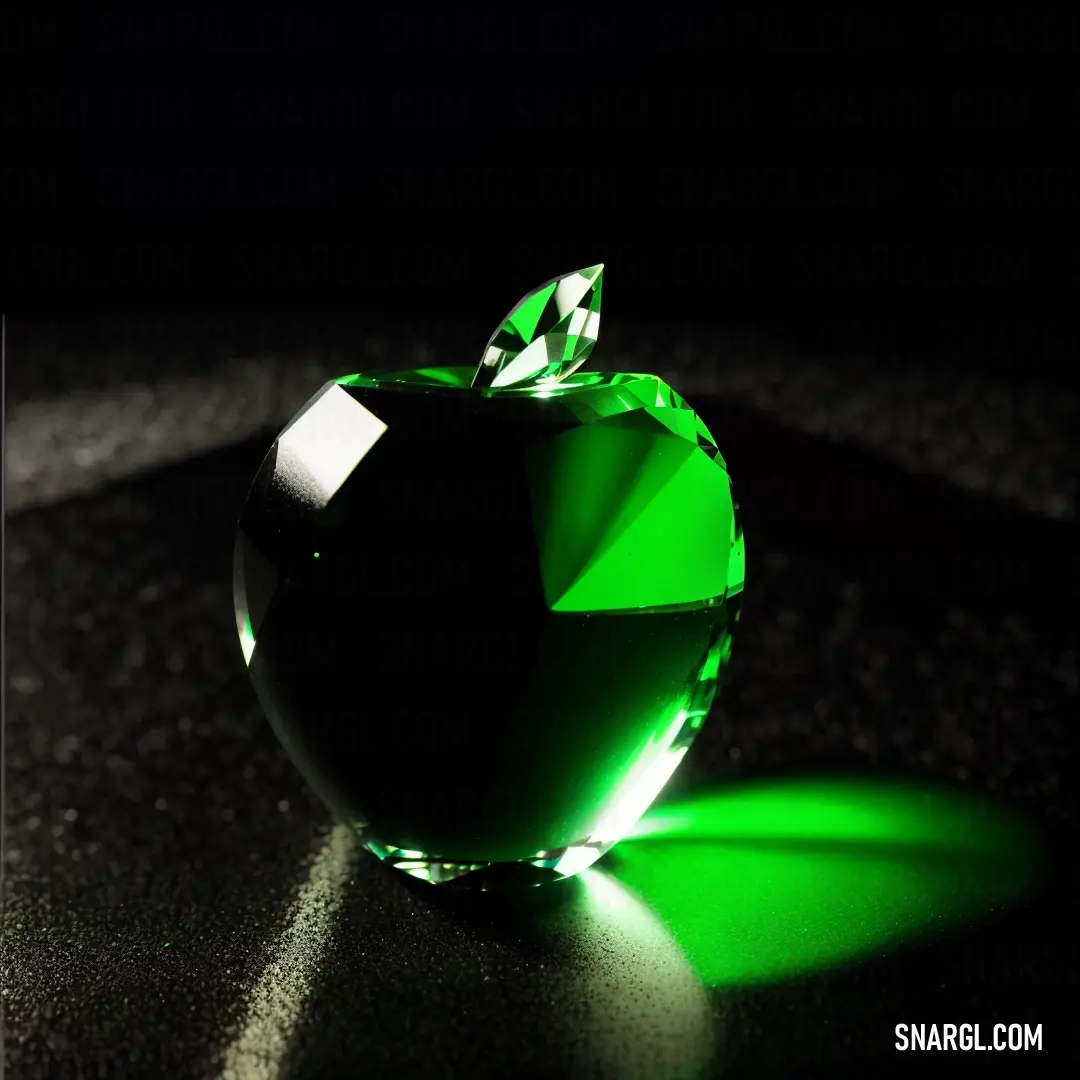 Green apple with a leaf on top of it on a table with a shadow on the ground and a black background
