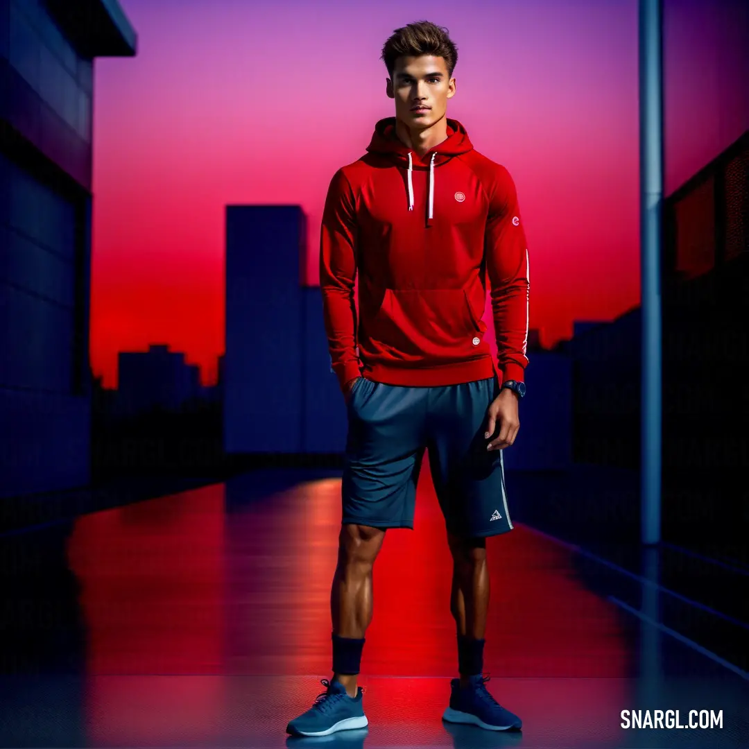 Man in a red hoodie and shorts standing in a dark room with a red and purple background