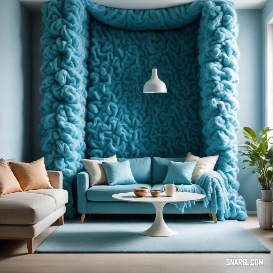 Living room with a blue couch and a blue wall with a large chunky blanket on it's back. Example of CMYK 43,14,0,6 color.