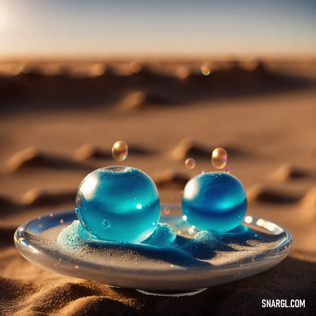 Plate with two blue balls on it in the sand at the beach with bubbles in the air and a sun shining in the background