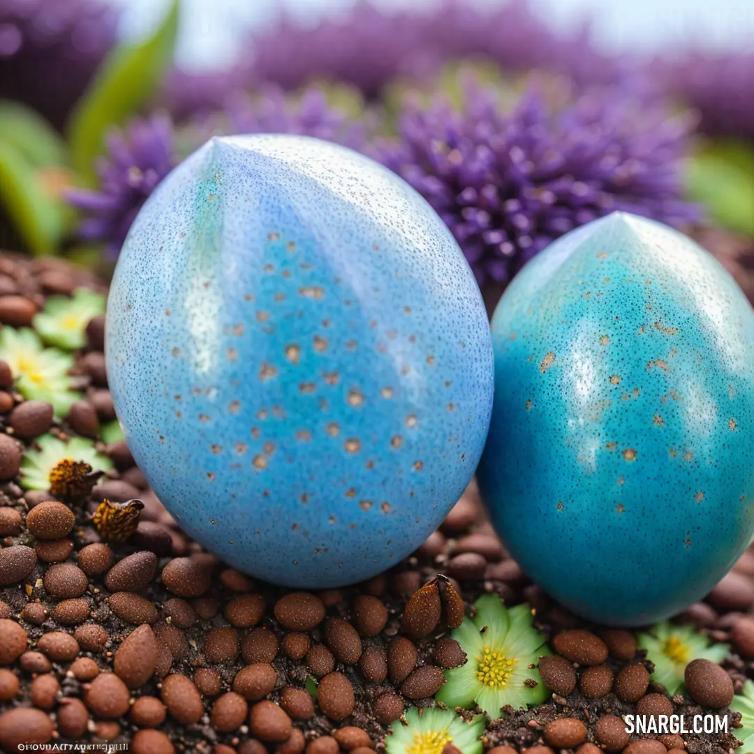 Two blue eggs on top of a pile of brown rocks and flowers in the background