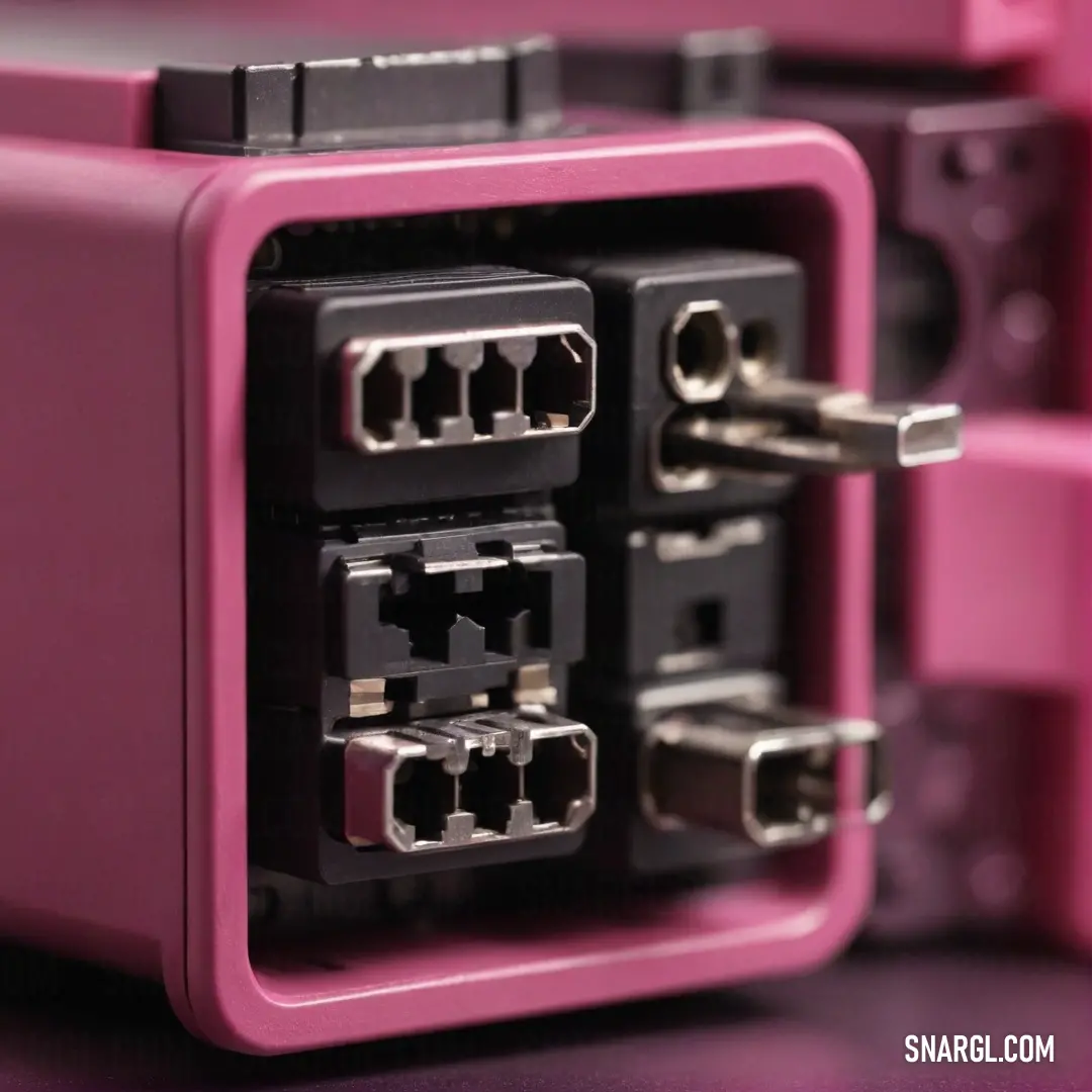 A vibrant pink and black device adorned with multiple wires and plugs, presented against a soft backdrop. The image highlights the striking RGB color combination of 255, 228, 196.