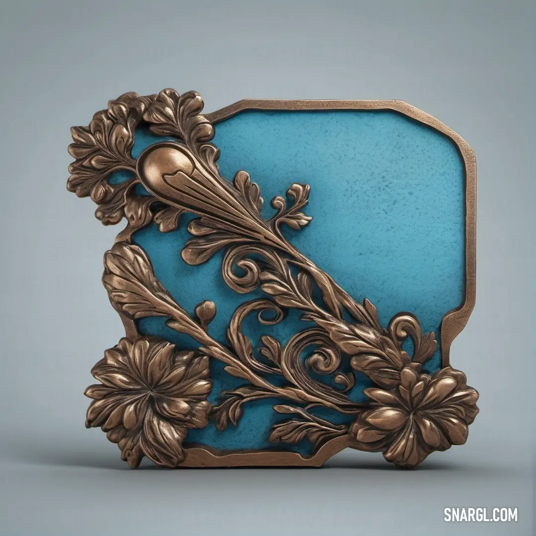 Blue and gold plaque with a bird on it's side and a flower design on the front. Color Blue Gray.
