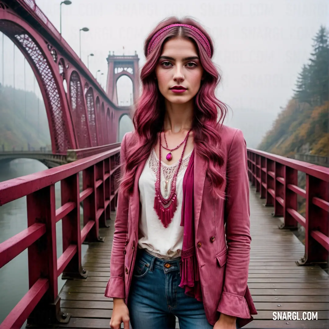 Woman with pink hair standing on a bridge with a red bridge in the background