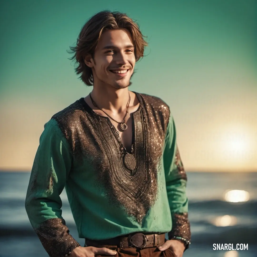 Man standing on a beach with his hands in his pockets and smiling at the camera with the sun in the background