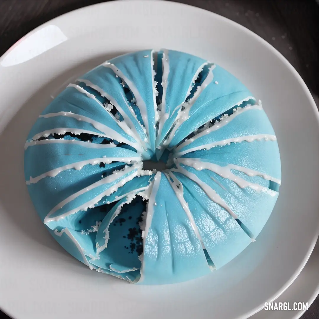 Blue cake with white icing on a plate on a table with a knife