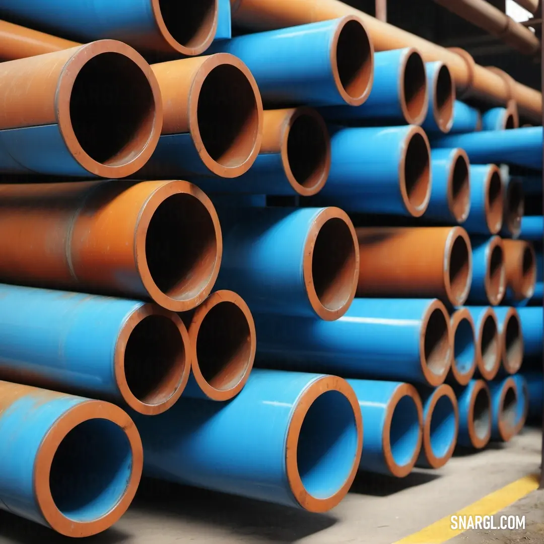 Bright cerulean color. Stack of blue and orange pipes in a warehouse area with a yellow line on the floor