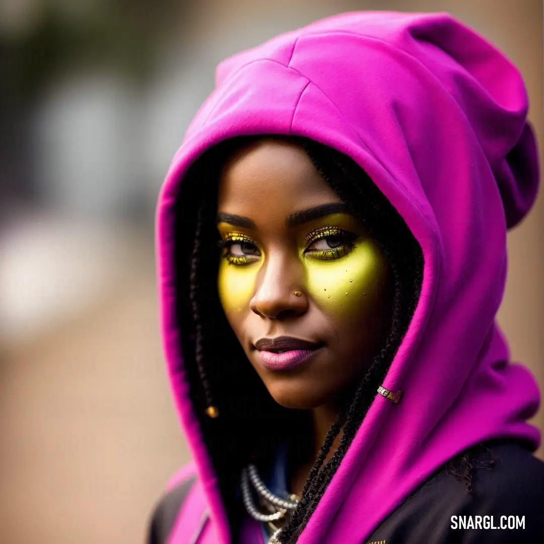 Woman with a yellow face paint and a pink hoodie on her head and a necklace on her neck