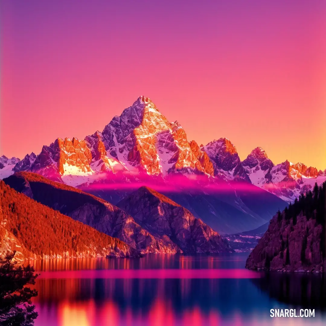 Mountain range with a lake and trees in front of it at sunset with a pink sky