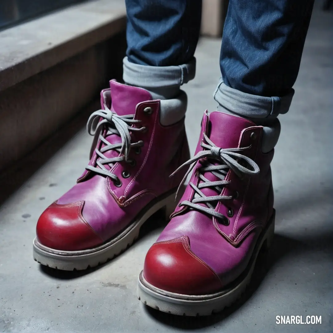 Person wearing red and pink boots standing on a step way with their legs crossed. Color CMYK 0,100,75,50.