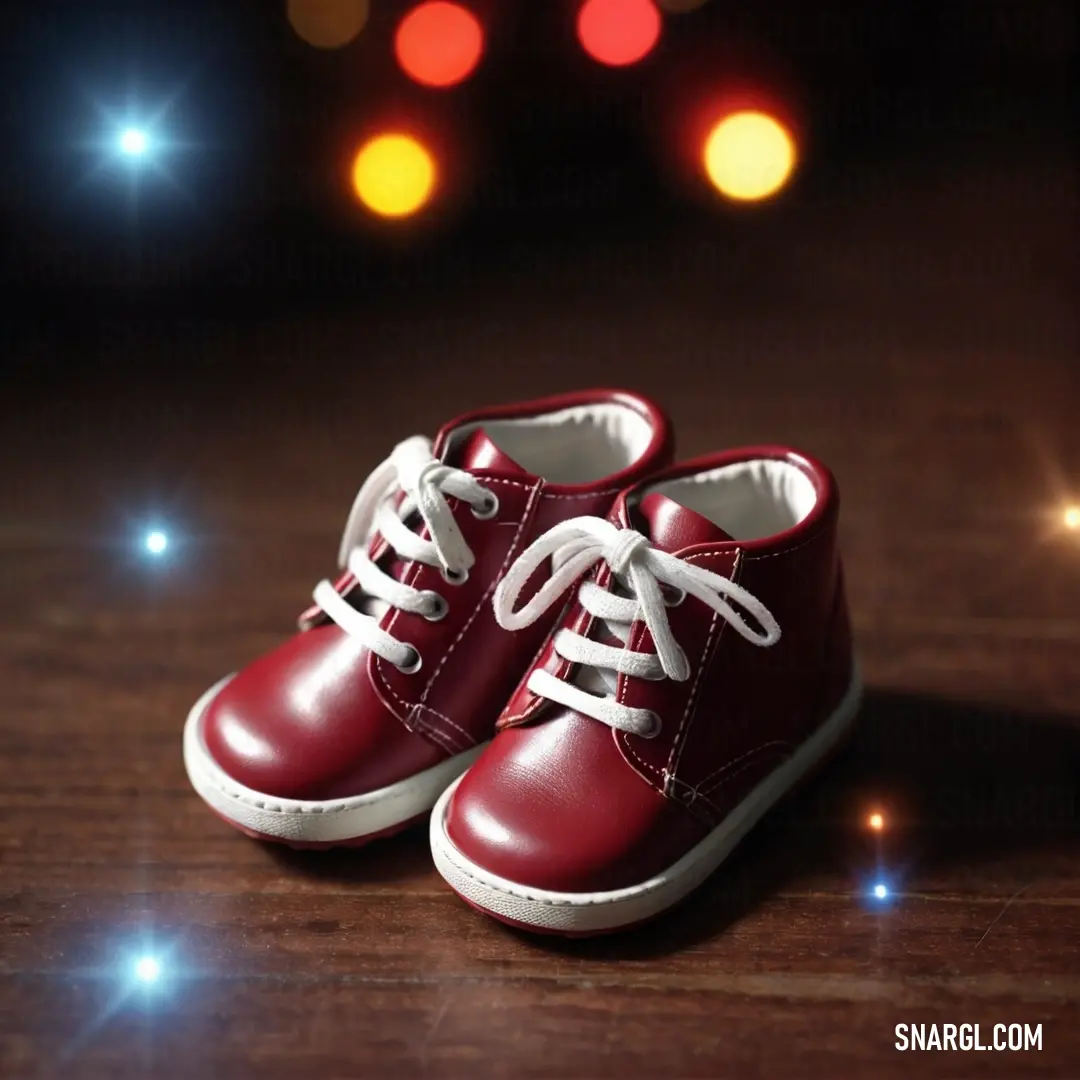 Pair of red shoes on top of a wooden table next to a red light bulb and a black background. Example of Burgundy color.