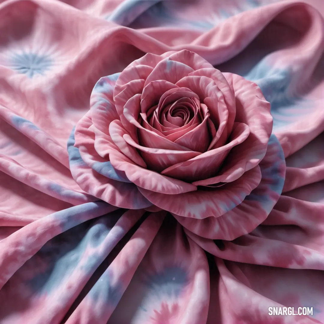 Pink rose is shown on a pink and blue tie dye fabric with a flower in the center of the image