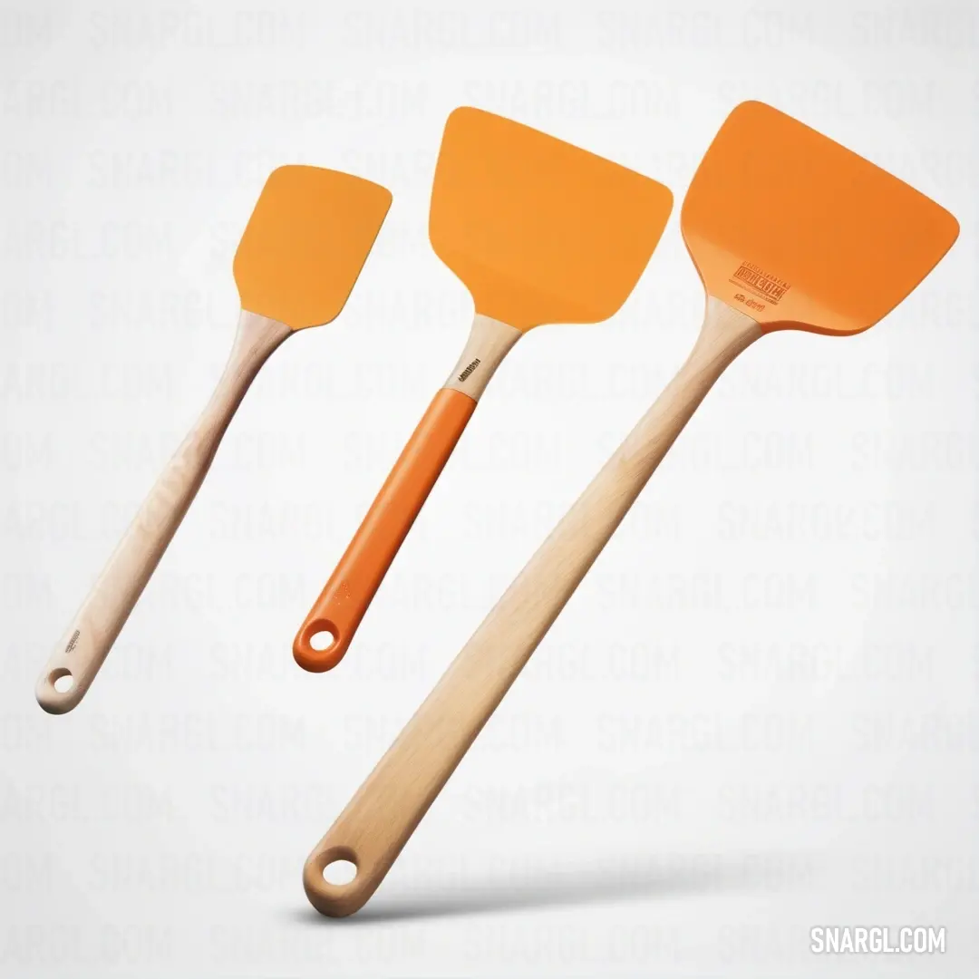 Three orange spatulas with wooden handles on a white background. Example of #ED872D color.