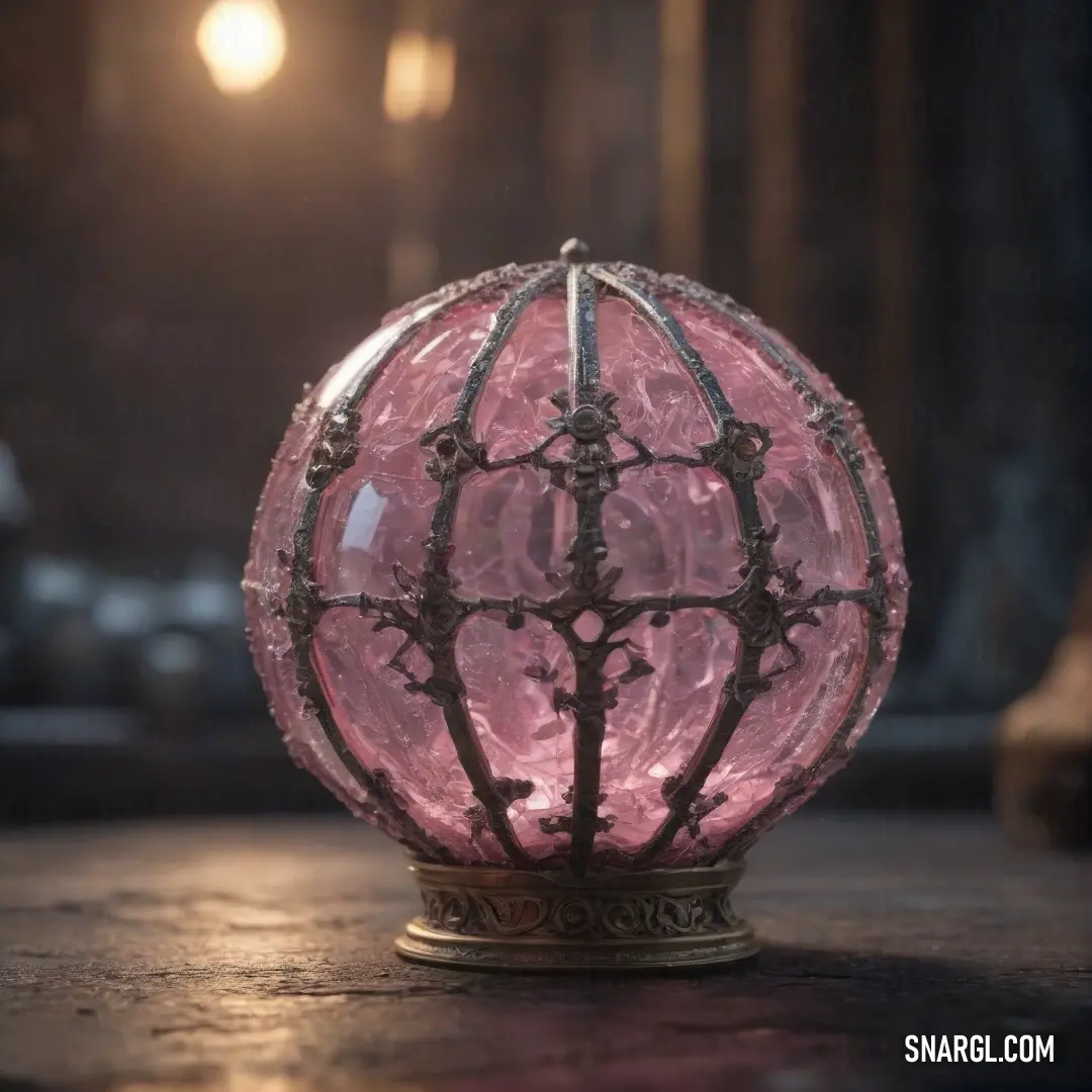 A glowing pink glass orb resting on a metal stand in a dimly lit room. The soft pink hue of the ball contrasts beautifully with the warm light spilling from a bulb overhead, casting a calming glow on its surroundings.