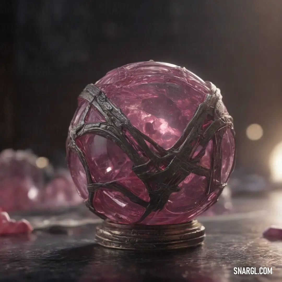 A shimmering pink glass orb with a futuristic, metallic fidget spinner perched on top, placed delicately on a table surrounded by various other objects. The soft pink hue of the ball contrasts with the cool metallic elements.