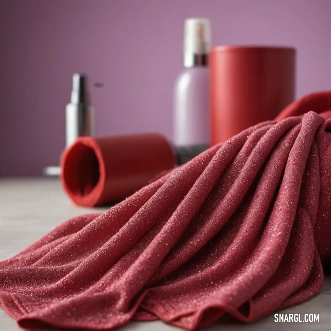 A lush, cozy setting featuring a vibrant red towel artistically draped over a table, accompanied by a sleek bottle of lotion and a steaming cup of coffee, all reflecting the warmth and comfort of an inviting space infused with a candy pink hue.