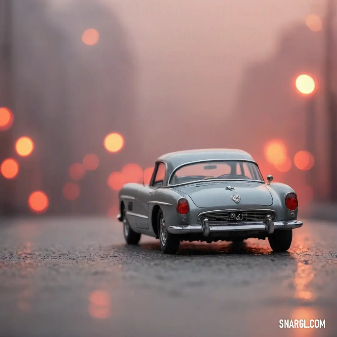 A vibrant toy car rests on a rain-soaked road, glistening under lights that create a dreamy bokeh effect in the background, perfectly embodying the lively spirit of color #E4717A.