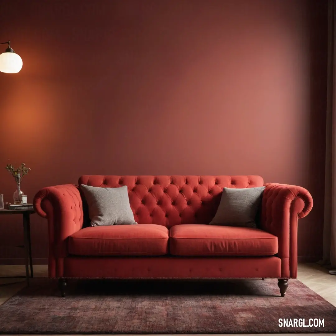 A plush red couch adorned with two inviting pillows creates a cozy nook in a room with striking red walls. The charming ambiance is enhanced by a lamp, making this a perfect spot to relax and unwind.