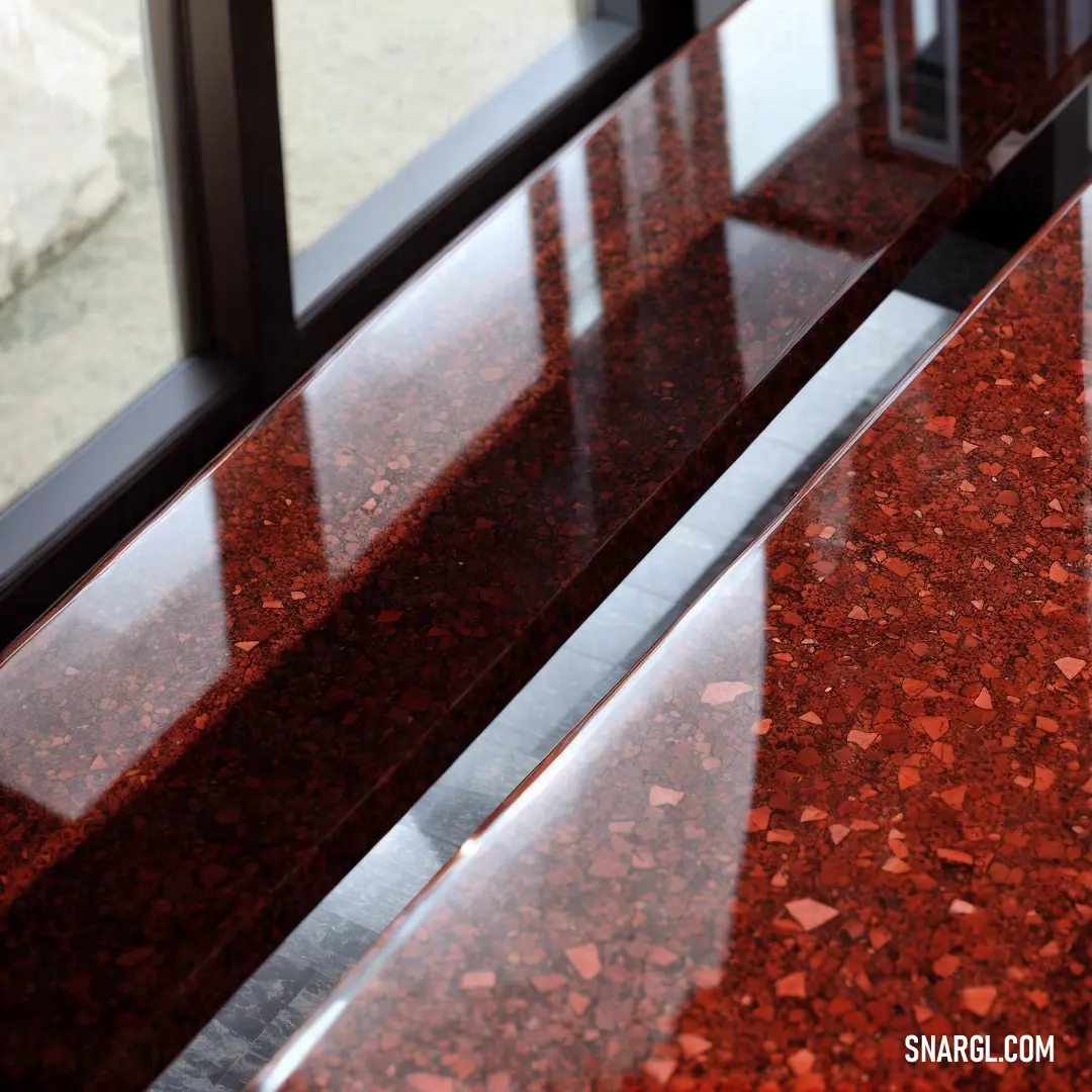 Red counter top sitting next to a window with a glass door in it's center area and a window behind it