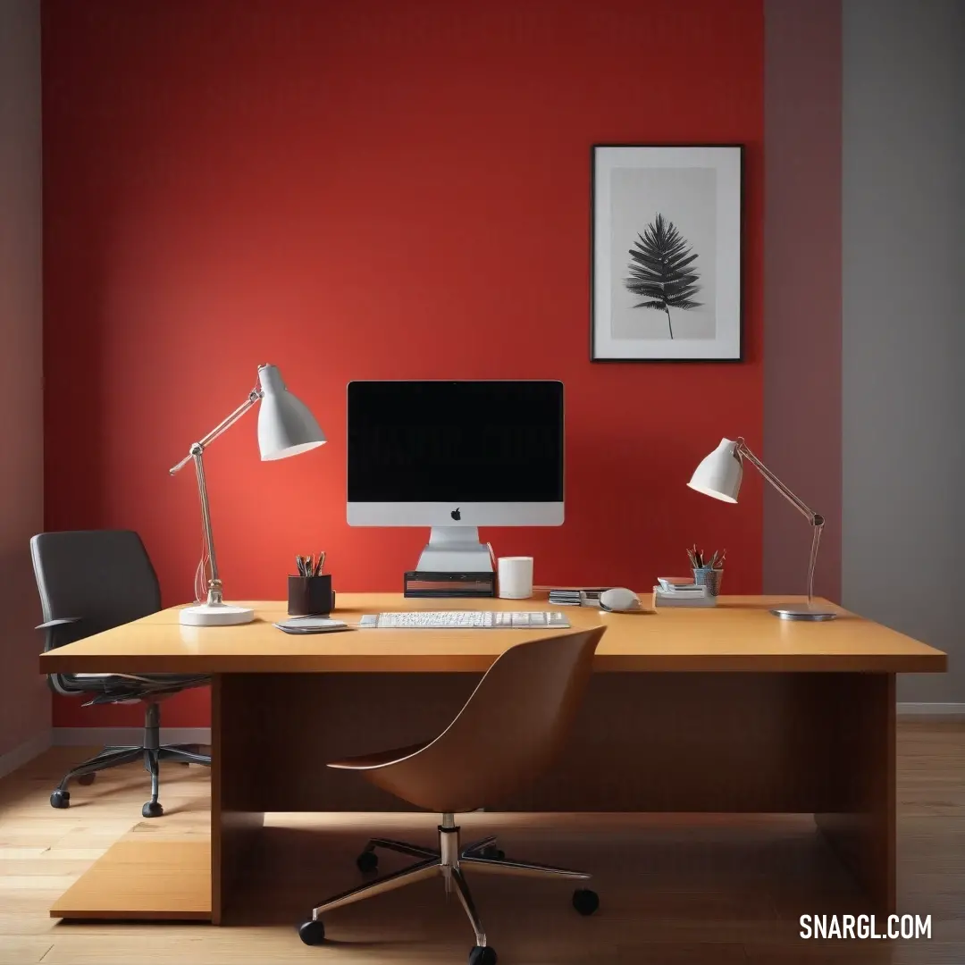 Desk with a computer and a chair in a room with a red wall and a black chair. Color Carnelian.