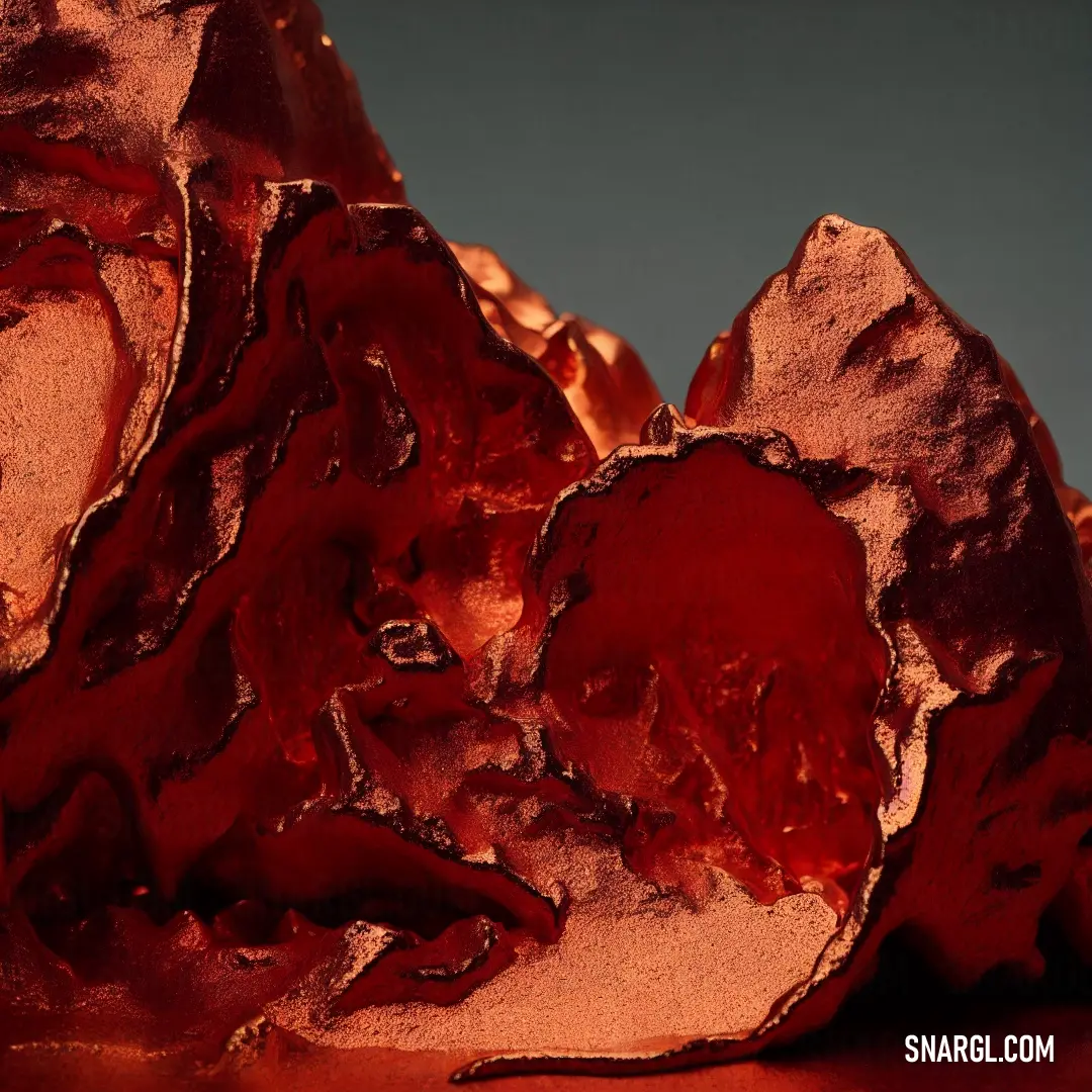 Close up of a red rock with a blue background and a white background behind it