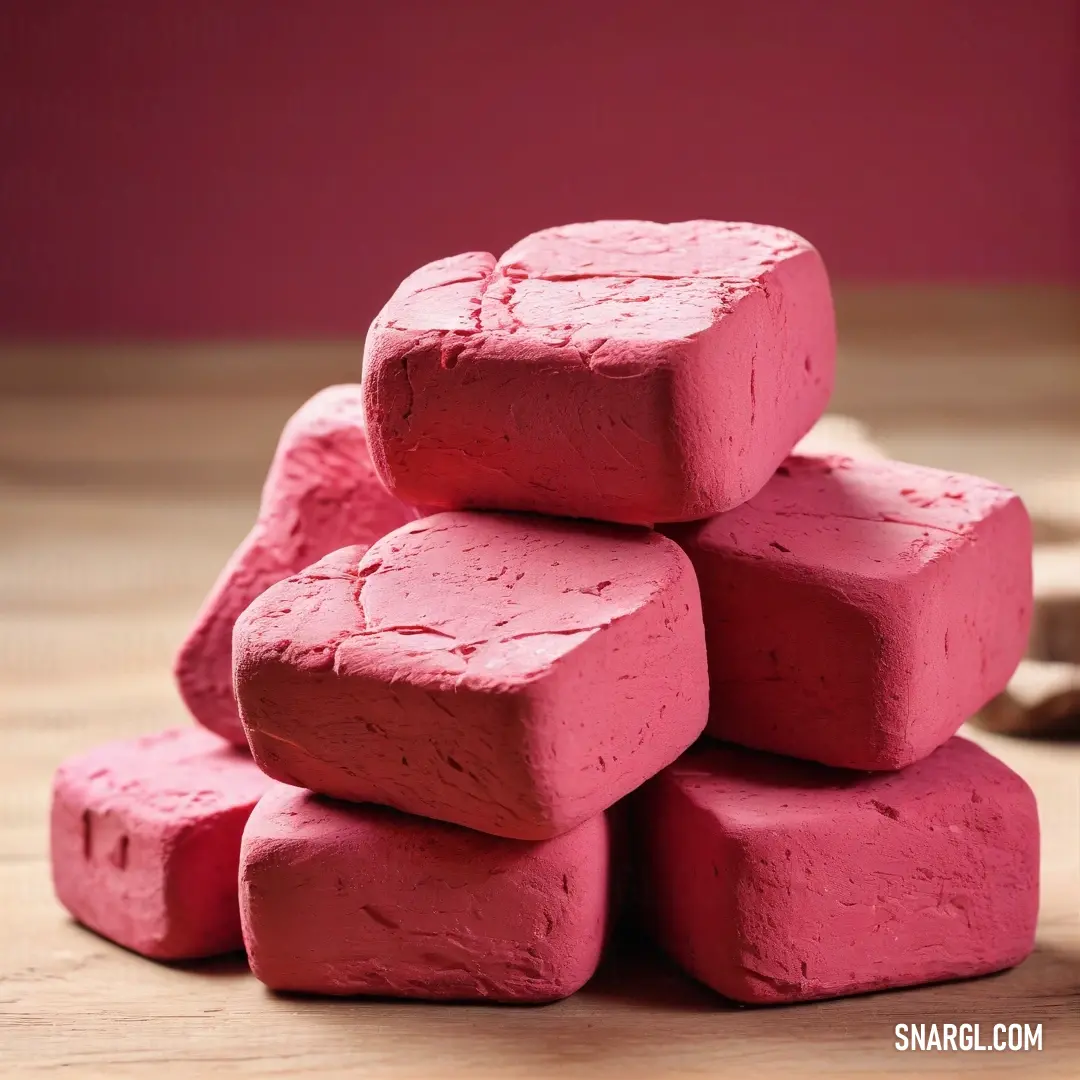 Pile of pink colored rocks on a wooden table next to a banana peel. Color Cerise pink.