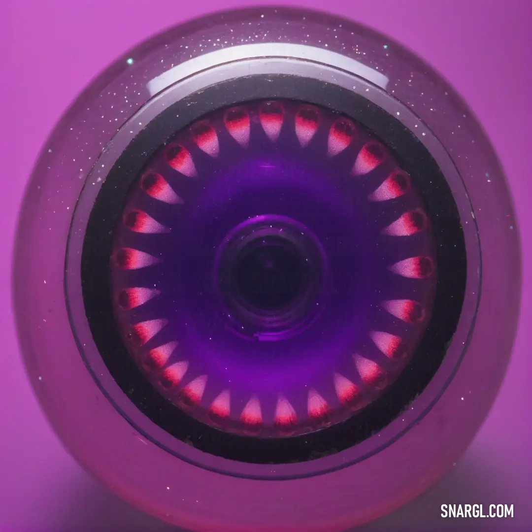 Purple object with a red light inside of it on a purple surface with a pink background. Example of CMYK 0,78,55,13 color.