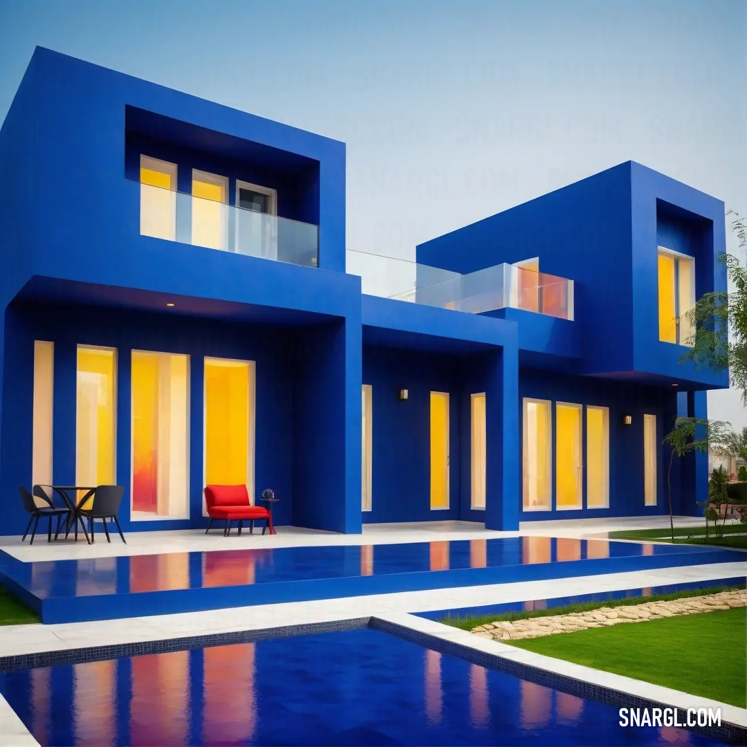 Cerulean blue color example: Blue house with a pool and a red chair in front of it