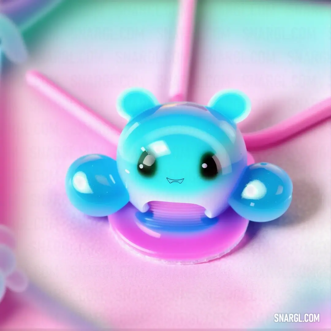 Blue toy with a big smile on it's face sitting on a pink surface with a pink and blue background