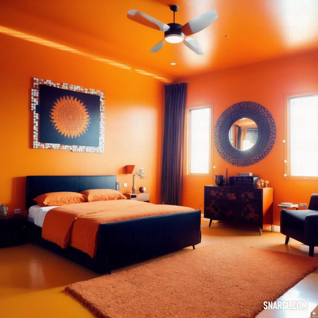 Bedroom with orange walls and a black bed and chair and a mirror on the wall and a ceiling fan