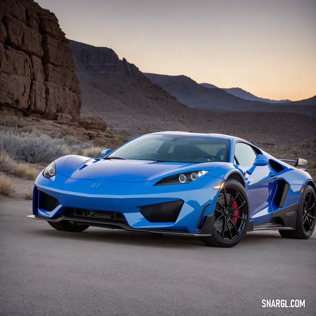 Blue sports car parked in a desert area at sunset with mountains in the background and a sky line. Color #0047AB.