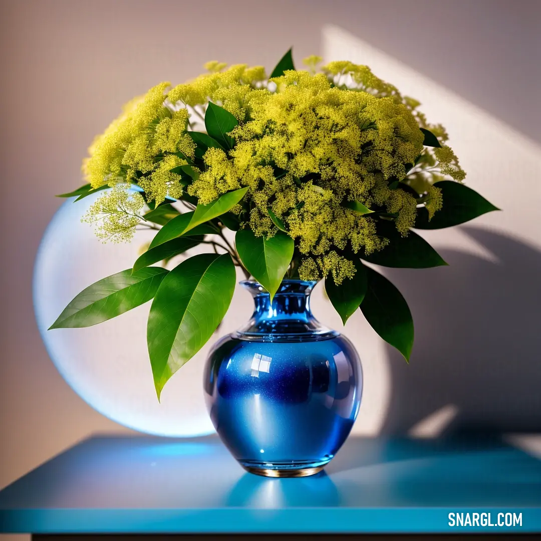 Blue vase with yellow flowers in it on a table with a white wall behind it and a blue table. Example of RGB 0,71,171 color.