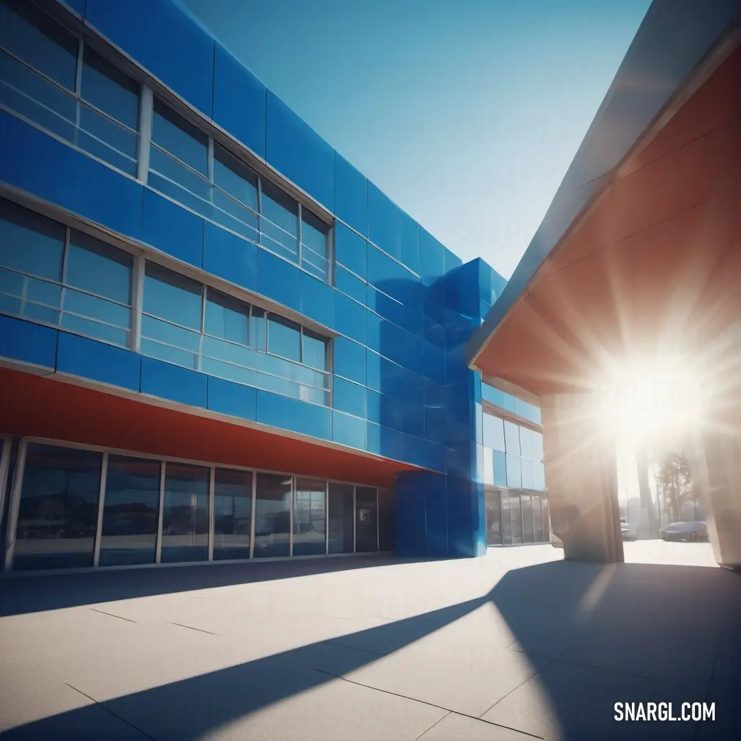 Building with a blue and red facade and a sun flare in the background. Example of #002E63 color.