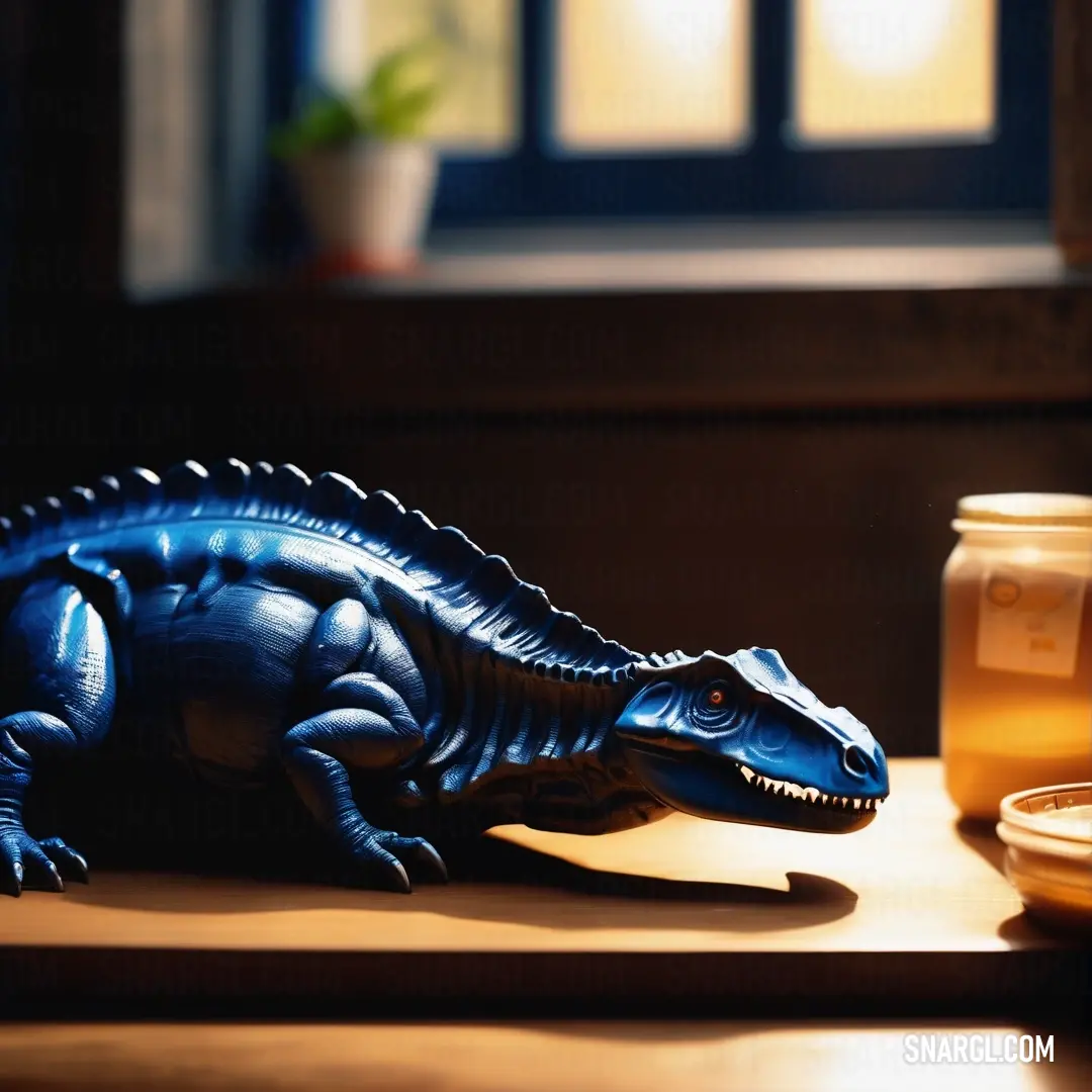 Plastic lizard on a table next to a jar of honey. Color RGB 0,46,99.