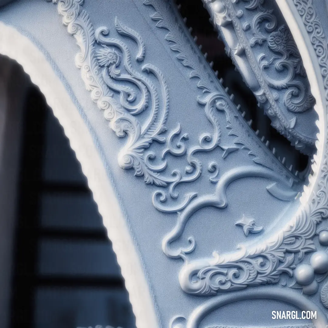 Close up of a decorative white piece of furniture with intricate designs on it's sides