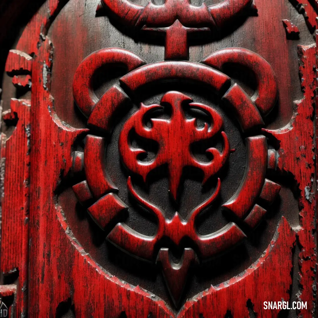 Red door with a decorative design on it's side door frame and a circular design on the front