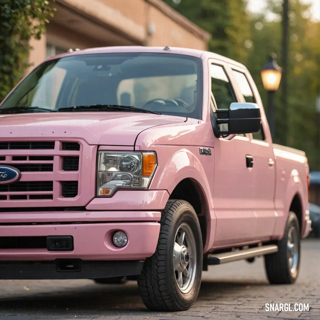 Cotton candy color example: Pink truck parked on the side of a road next to a building and a street light with a lamp on