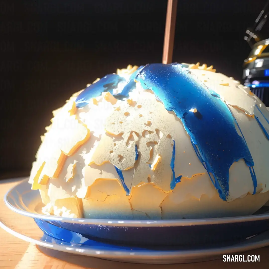 Cake with blue and white icing on a plate on a table with a blue and white plate. Example of CMYK 100,100,0,45 color.
