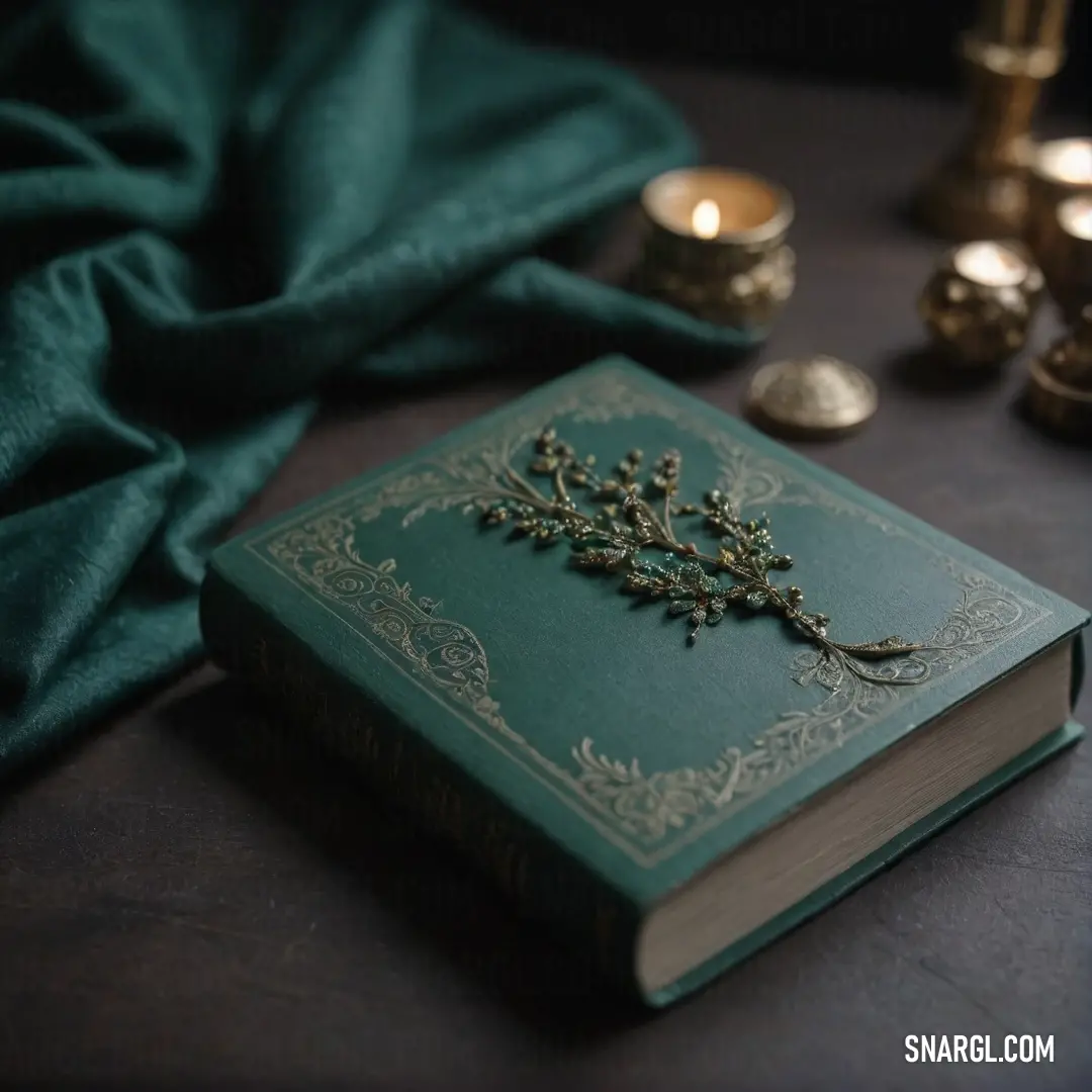 A lush green book adorned with a delicate gold decoration, resting beside a flickering candle and soft green cloth on a wooden table. The gold accents on the book catch the light, adding a touch of elegance to the peaceful setting.