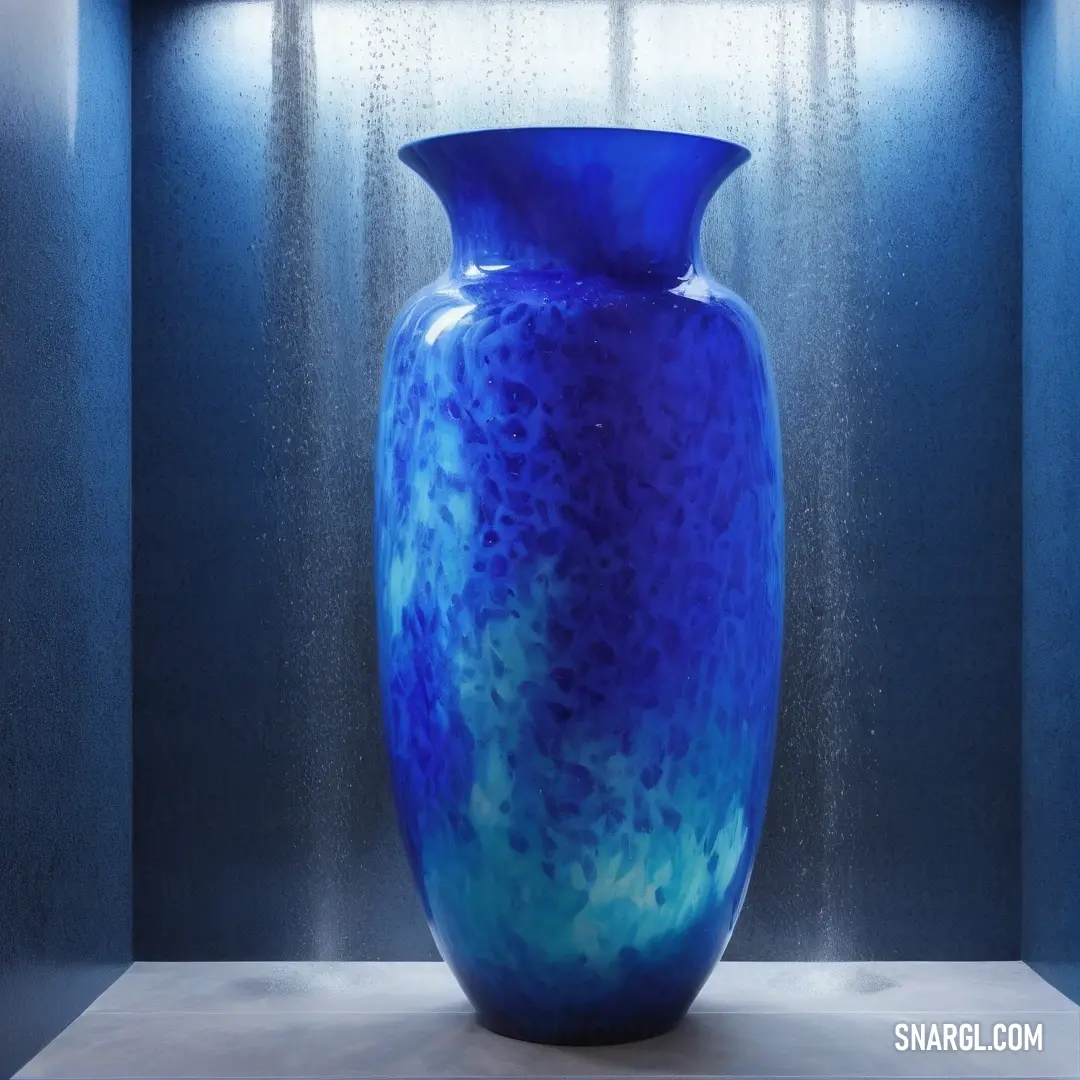 Dark cerulean color. Blue vase on a table in a room with a blue wall and a light on it's side