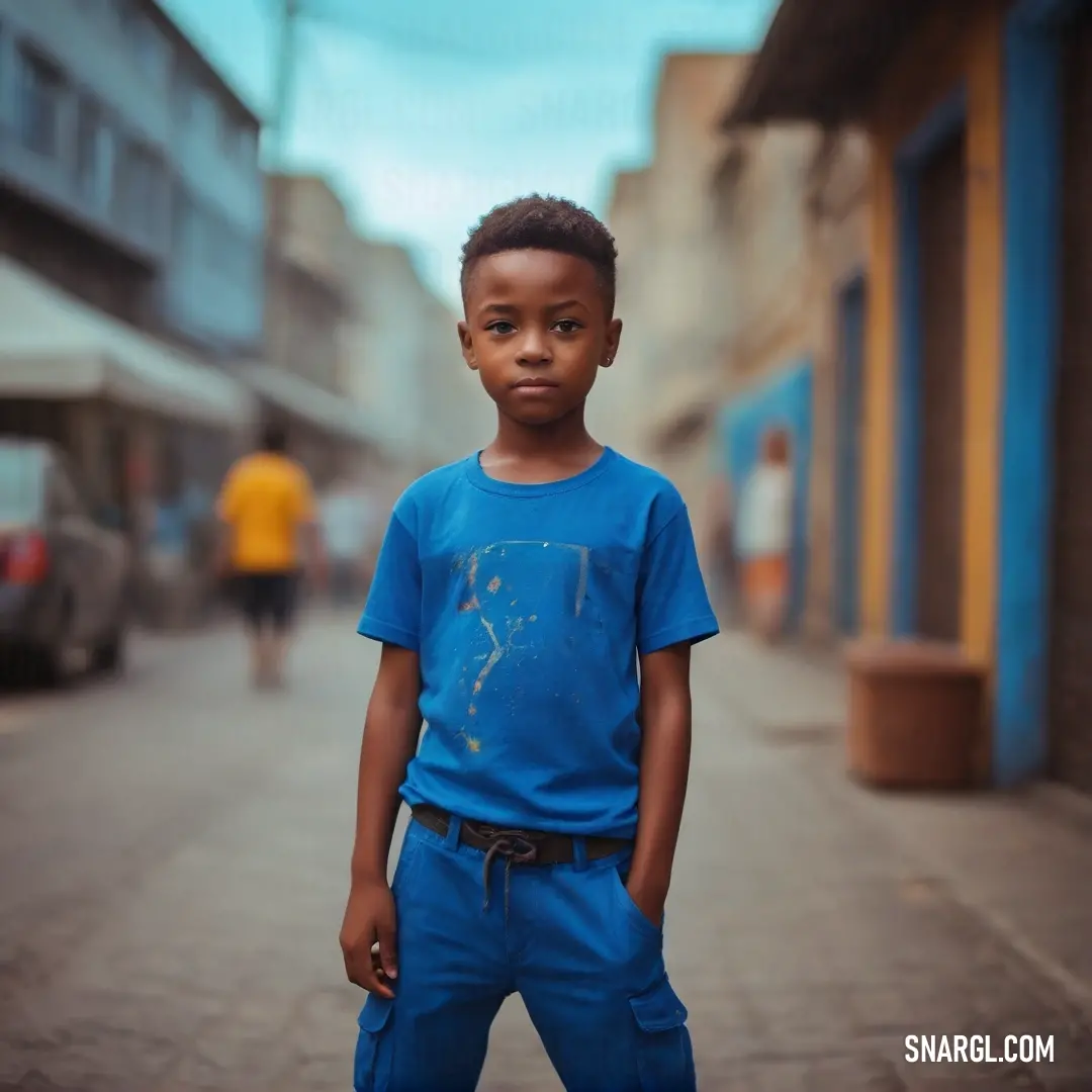Dark cerulean color example: Young boy standing on a street in a blue shirt and blue pants with a black belt around his waist