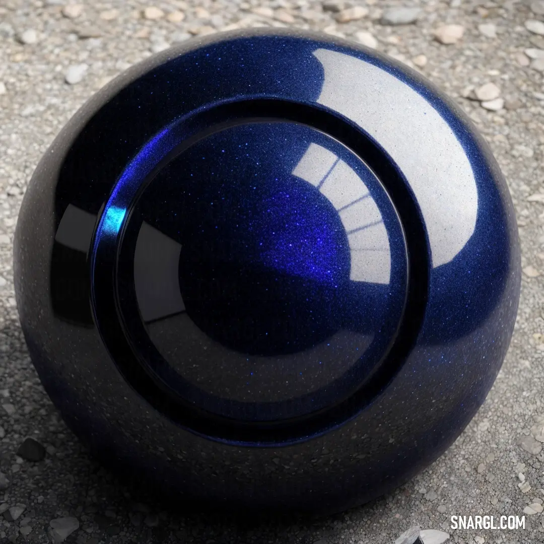 Blue ball on the ground with gravel around it and a blue light shining on it's side. Example of CMYK 94,79,0,43 color.